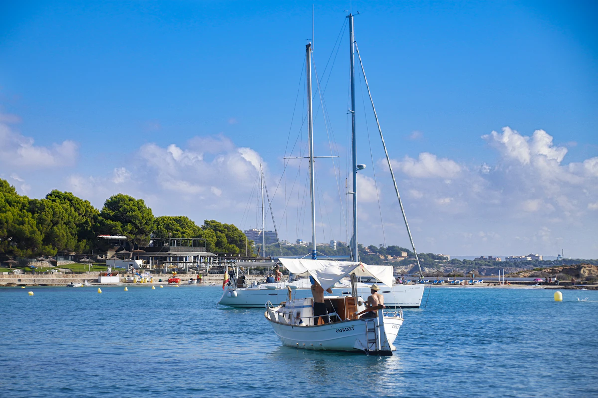 Seilbåter ankret ved en strand i Palma
