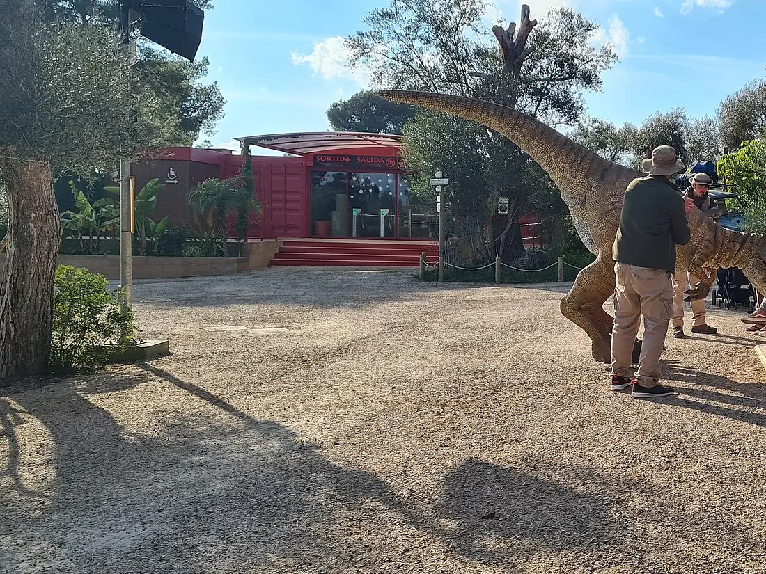 Dinosaurmodell i full størrelse og en ansatt på plassen i Dinosaurland