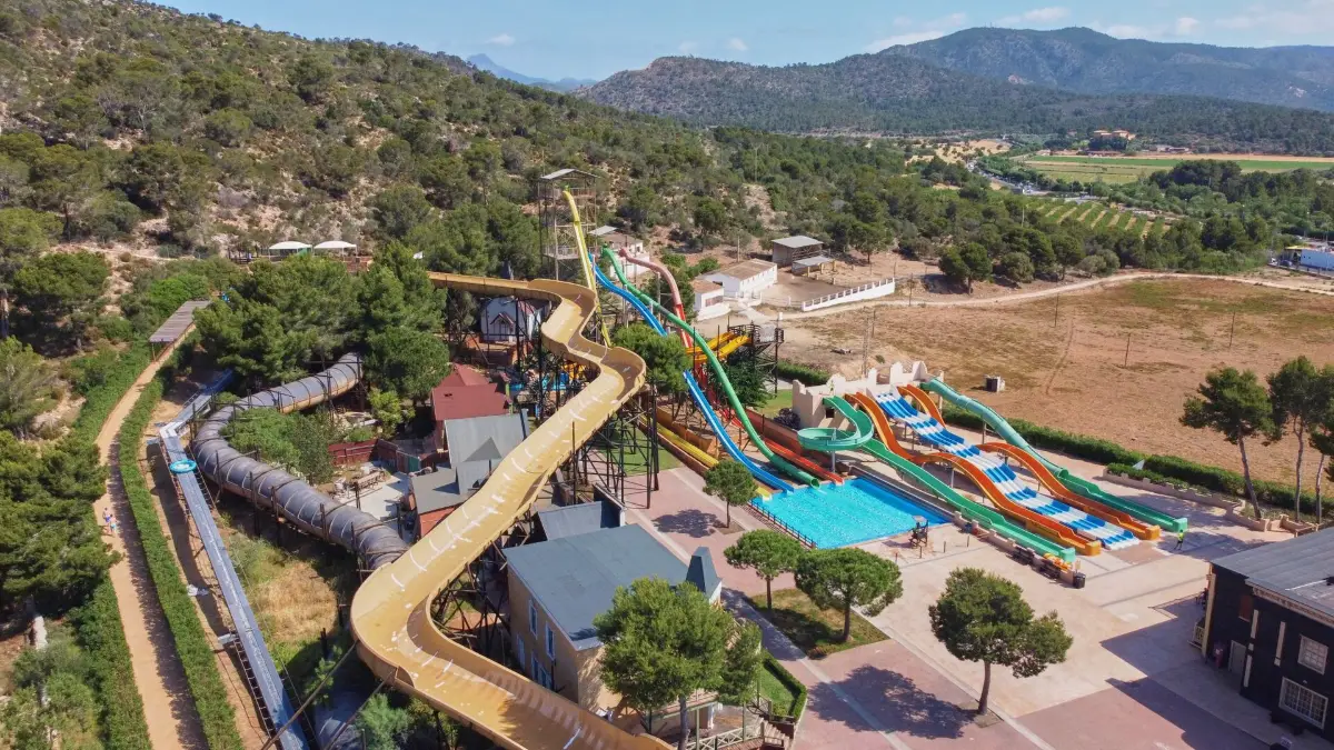 Vannsklier og basseng i Western Water Park sett ovenfra, med fjellene bak