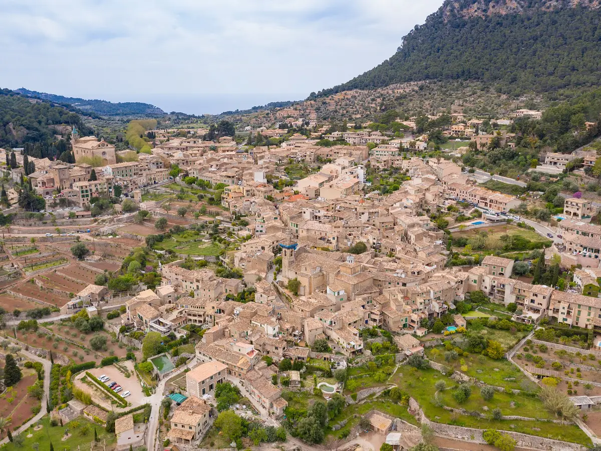 Valldemossa sett fra lufta, med steinhusene i dalen under fjellet